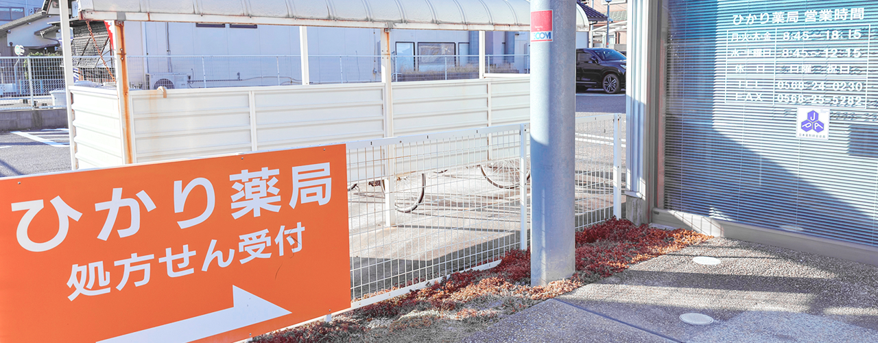 オレンジ色の看板を含む、ひかり薬局の外観写真