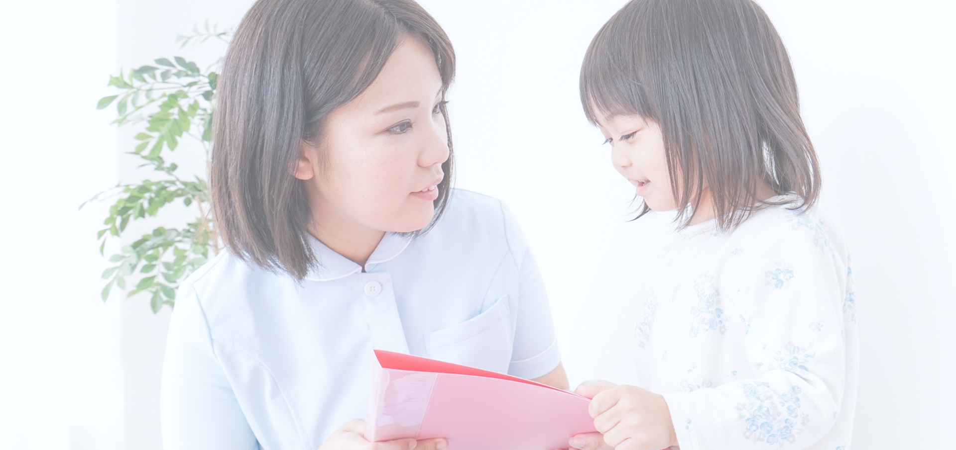 目線の高さを合わせて子どもに接する女性薬剤師