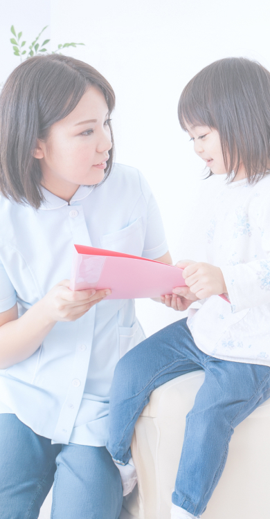 目線の高さを合わせて子どもに接する女性薬剤師