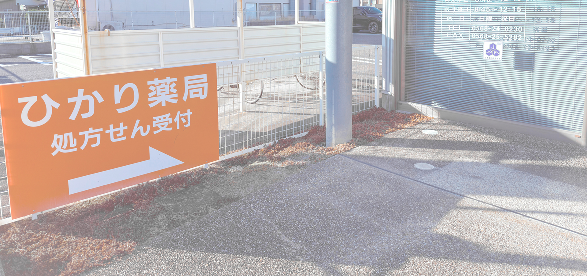 オレンジ色の看板を含む、ひかり薬局の外観写真